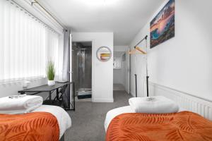 a room with two beds and a table in it at Sittingbourne Lodge, free car park - 4 Cars in Sittingbourne