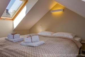 a bedroom with a large bed with towels on it at Marina Jastarnia Apartamenty in Jastarnia +45 photos