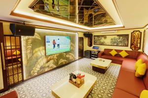 a living room with a couch and a tv at Sunny Beach Resort & Spa Mui Ne in Mui Ne