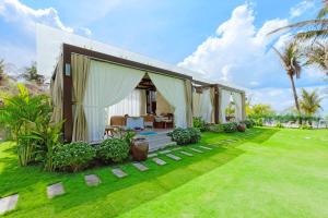 a house with a grass yard with a house at Sunny Beach Resort & Spa Mui Ne in Mui Ne