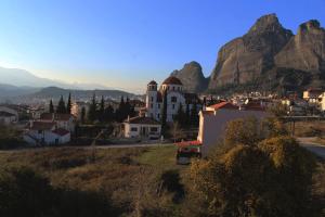 una vista di una città con una montagna sullo sfondo di In the Shadow of Meteora a Kalabaka