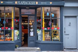 a store front of a bakery with a display window at Luxurious Large Townhouse in the Heart of Barbican in Plymouth