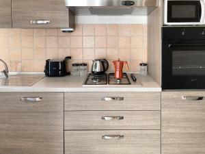 a kitchen counter with a stove and a microwave at Casa Riggi in Agliano Terme