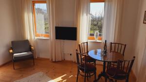 una sala da pranzo con tavolo e sedie e una televisione di Aich21 a Peissenberg