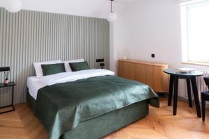 a bedroom with a bed with a green blanket at Grodzka Boutique Aparthotel - Stare Miasto in Jelenia Góra