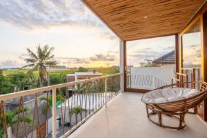 a balcony with a chair and a view of the ocean at Pagi Villas by Betterplace in Canggu