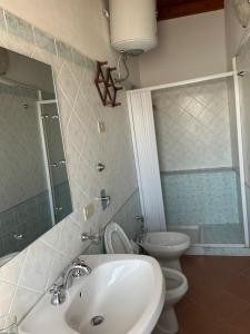 łazienka z umywalką, toaletą i lustrem w obiekcie City Loft w mieście Marsala