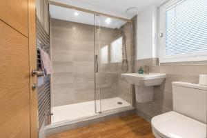a bathroom with a shower and a toilet and a sink at Forge Bridge House Coniston in Coniston +11 photos