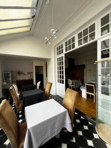 a dining room with a white table and chairs at Chambres d'Hôtes Au coin du spa in Boulogne-sur-Mer