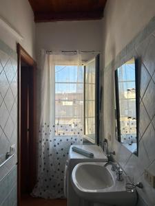 łazienka z umywalką, lustrem i oknem w obiekcie City Loft w mieście Marsala