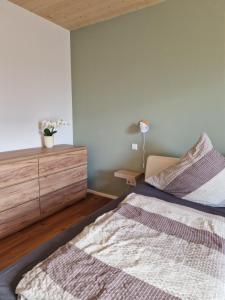une chambre avec un lit et une commode en bois dans l'établissement FeWo2 großräumige FeWo in Riegel am Kaiserstuhl über 2 Etagen, Galerie, Balkon, à Riegel am Kaiserstuhl