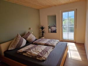 une chambre avec un lit et une grande fenêtre dans l'établissement FeWo2 großräumige FeWo in Riegel am Kaiserstuhl über 2 Etagen, Galerie, Balkon, à Riegel am Kaiserstuhl