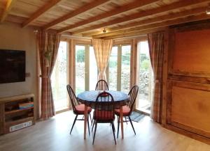 a dining room with a table and chairs and windows at Stone Moor Lodge Justin's Peak District Base Camp in Sheffield +9 photos