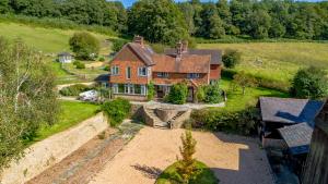 an aerial view of a large brick house at Stunning Countryside Home in Surrey by 53 Degrees Property, Ideal for Family Getaways, Private Tennis Court! in Hascombe