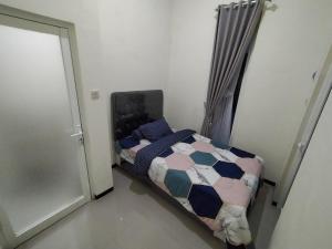 BAROKAH Cordoba Homestay 1 Rumah dgn 3 Kamar في Tlekung: غرفة نوم صغيرة بها سرير وباب +4 صور