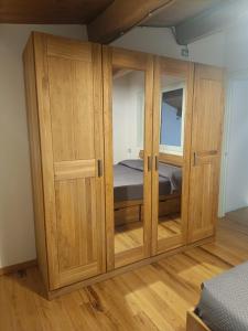 a wooden cabinet in a bedroom with a bed at La Dimora degli Scalzi Cabras in Càbras