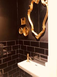 a bathroom with a white sink and a mirror at California Suite Wenduine in De Haan +28 photos