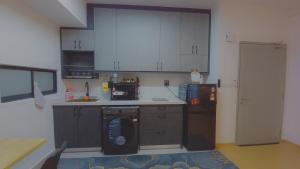 a kitchen with a washer and a dishwasher in it at LuuMa Gamuda Cove in Cyberjaya