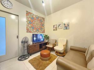 バギオにある1 Bed Flat - Pool - Parking - Wifiのソファとテレビのあるリビングルーム