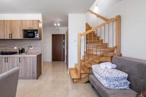 a living room with a couch and a staircase at ZABRZE Apartamenty Kościuszki 30 in Zabrze