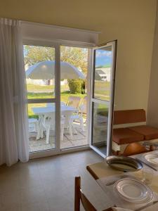 a dining room with a table and an umbrella at VVF Fouesnant les Glénan in Fouesnant