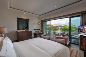 a bedroom with a large bed and a balcony at Anantara Desaru Coast Resort & Villas in Desaru +37 photos