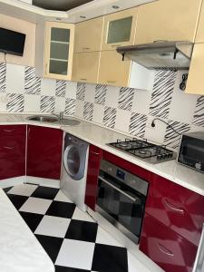 a kitchen with a washing machine and a checkered floor at Rent&Live large apartment in Chişinău