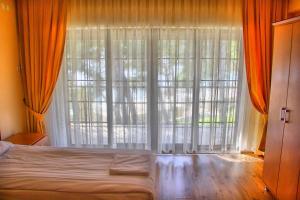 een slaapkamer met een bed en een groot raam bij Dardanos Yerleşkesi in Hamidiye +46 foto's