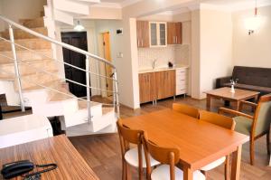 a living room and kitchen with a wooden table and chairs at Dardanos Yerleşkesi in Hamidiye
