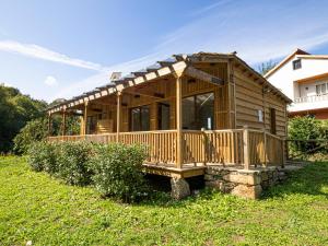 a wooden cabin with a roof on a grass field at Cabaña del Molinero in Palas de Rei