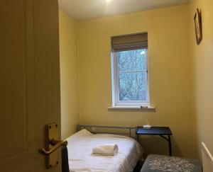 a small room with a bed and a window at Brades Rise Retreat - Cozy 3 Bedroom House in Oldbury