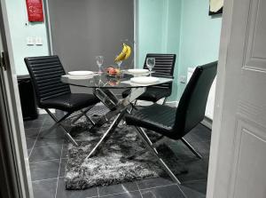 a dining table with four chairs and a banana on it at Brades Rise Retreat - Cozy 3 Bedroom House in Oldbury +11 photos