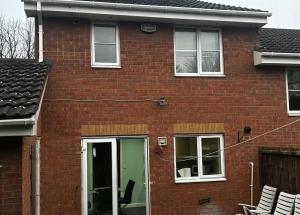 a red brick house with a green door at Brades Rise Retreat - Cozy 3 Bedroom House in Oldbury