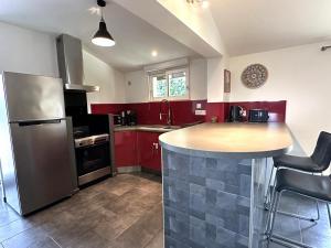 a kitchen with red cabinets and a island in the middle at La sauvagine in Soustons