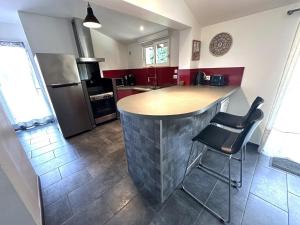 a kitchen with a island in the middle of a kitchen at La sauvagine in Soustons +13 photos