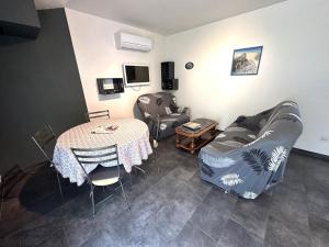 a living room with a table and a couch at La sauvagine in Soustons