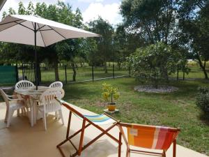 a patio with a table and chairs and an umbrella at La sauvagine in Soustons