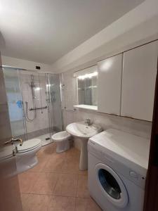 a bathroom with a toilet sink and a washing machine at Casetta bella vista in Aviatico