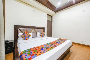 a bedroom with a large bed with a colorful blanket at FabHotel Royal Inn in Chandīgarh
