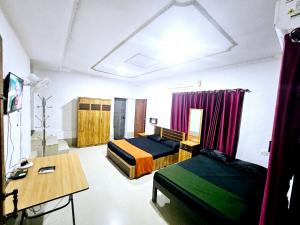 a bedroom with two beds and a desk and a table at GB 25 cottage's in Trivandrum