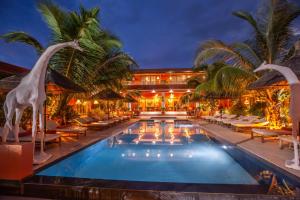 恩加帕鲁Maison de clara的一个带椅子和棕榈树的游泳池的度假酒店