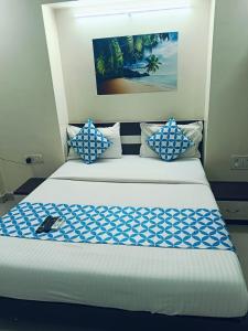 Un dormitorio con una cama con almohadas azules y blancas. en Nobel Studio, en Pune