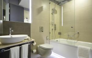 a bathroom with a sink, toilet and bathtub at Four Elements Ekaterinburg in Yekaterinburg