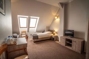 a small room with a bed and a television at Villa Pallas in Olsztyn +75 photos