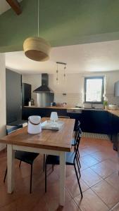 cocina con mesa de madera y 2 sillas en Maison 3ch - Parc Naturel du Verdon, en Quinson
