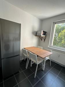 una cucina con un tavolo di legno e un frigorifero di City-Apartments Hannover ad Hannover