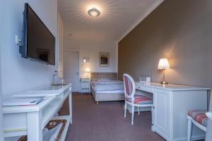 a room with a desk and a bedroom with a bed at Hotel Waldhof auf Herrenland in Mölln