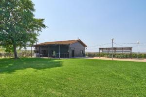 un ampio cortile con un edificio e un albero di La Cabaña piscina y jardín a La Carlota