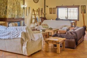 un soggiorno con divani e tavoli di La Cabaña piscina y jardín a La Carlota Altre 24 foto