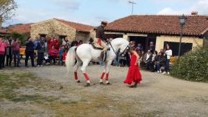 Um homem monta um cavalo branco com uma mulher. em Finca Los Caleros em Juan Gallegos